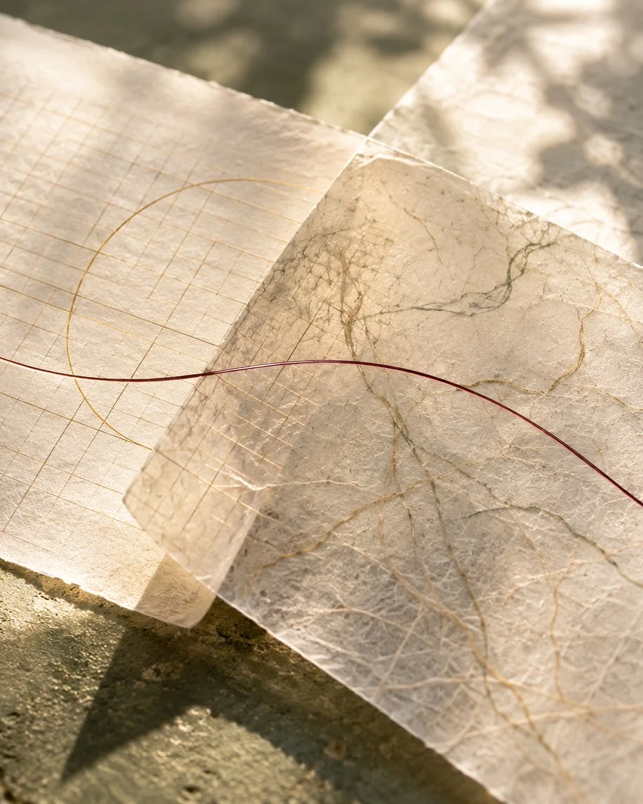 Two sheets of handmade paper crossed by a fine copper thread, for a guide to acupuncture during perimenopause and menopause