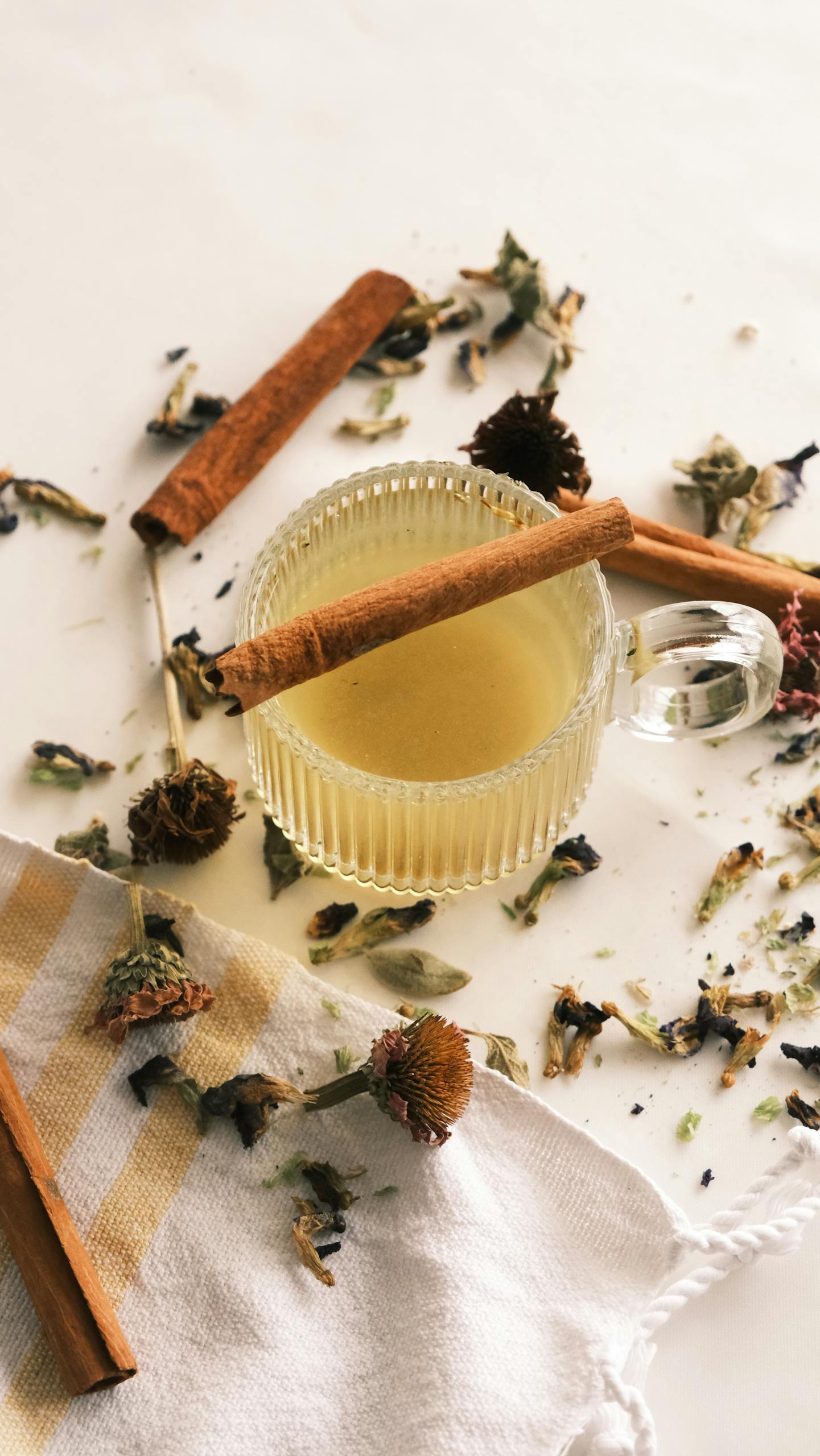 From Festive Feasts to Digestive Ease: 10 A cozy setup of herbal tea with cinnamon sticks and scattered dried herbs.